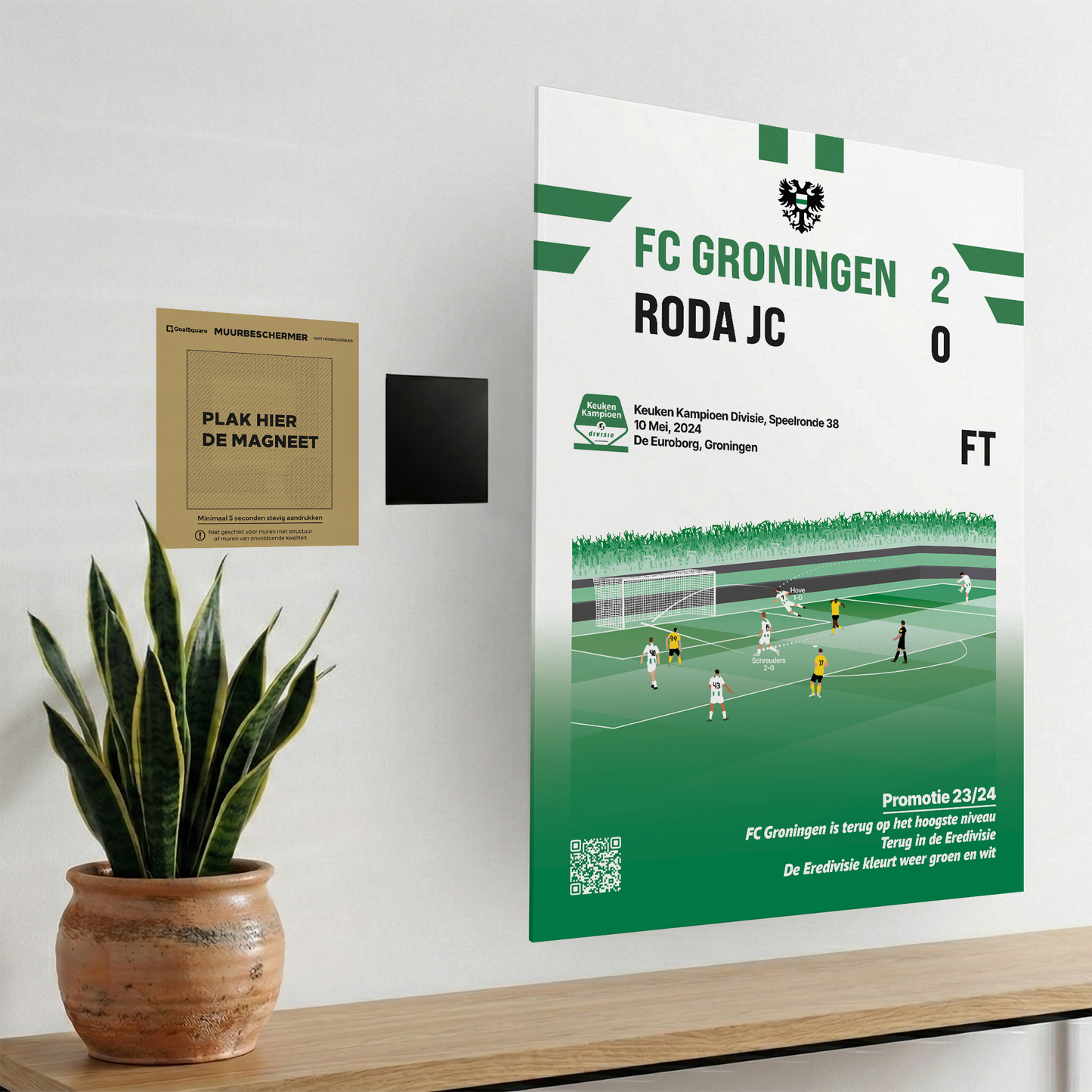 Het magnetische ophangsysteem van GoalSquare gedemonstreerd met de groen-witte Match Moment poster van de promotie van FC Groningen aan de wand.